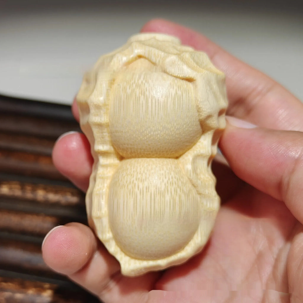 Solid natural bamboo peanut ornament with engraved message on wooden surface