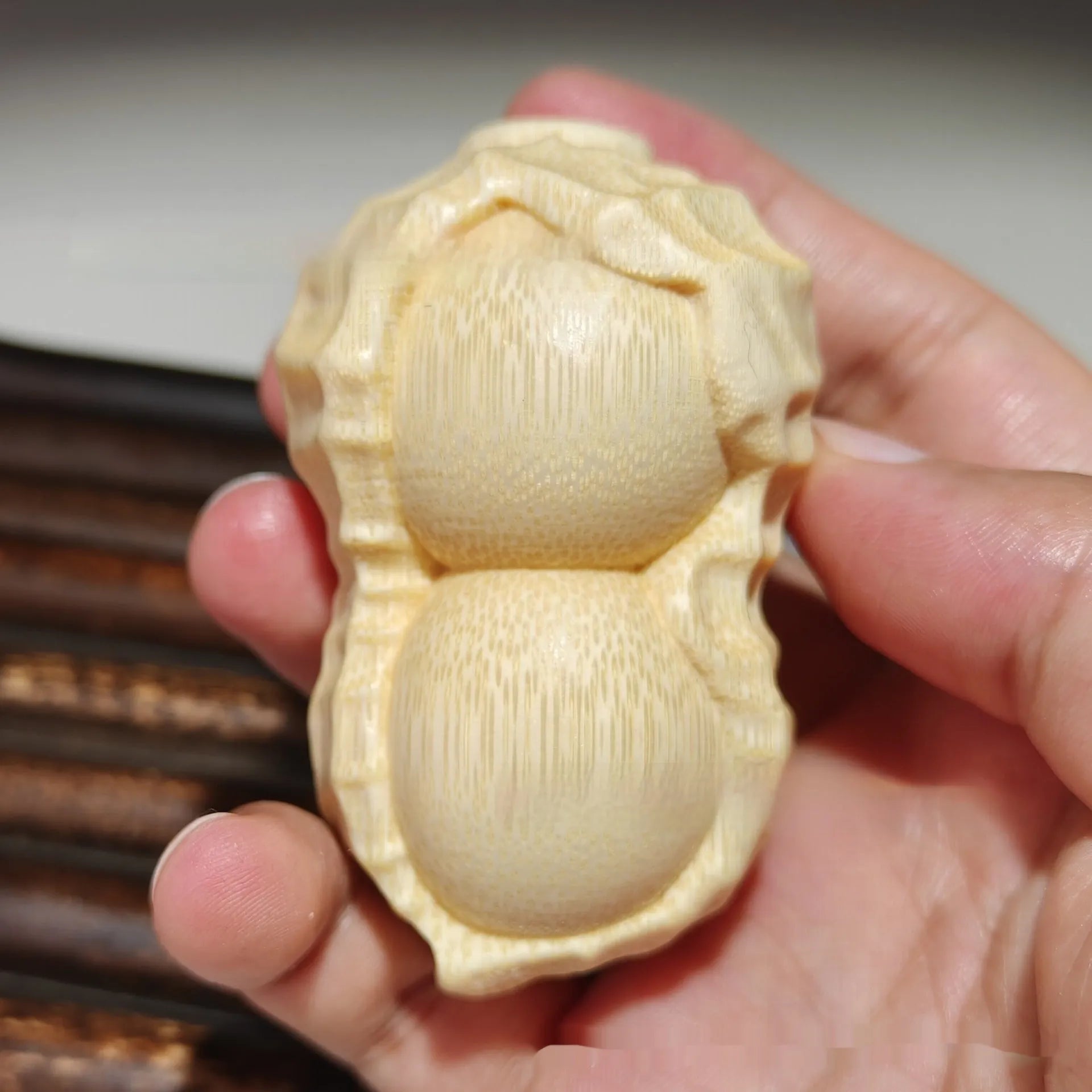 Solid natural bamboo peanut ornament with engraved message on wooden surface