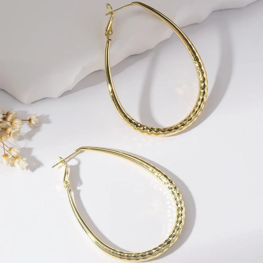 Gold glossy egg-shaped spring fastener earrings made from hypoallergenic copper, unisex geometric design