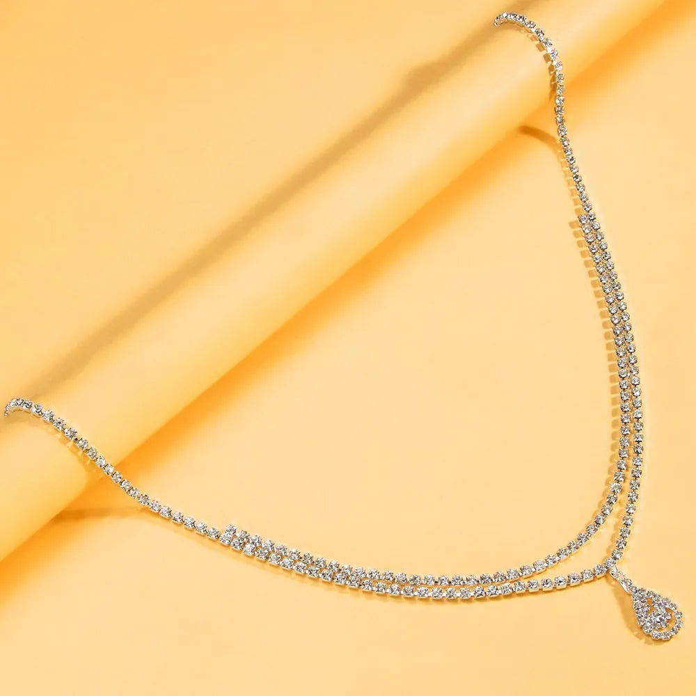 Gold or silver rhinestone waist chain with a water drop pendant and tassel detail
