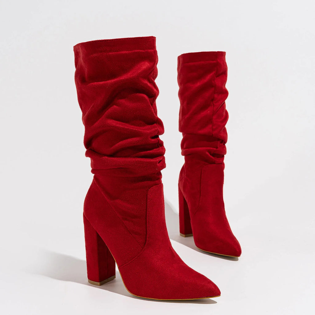 Women's black suede pointed-toe ankle boots with a chunky high heel, shown on a mid-calf.