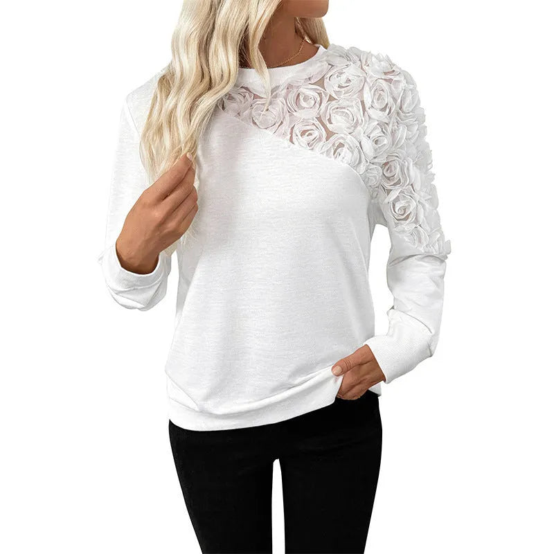 White loose fit long sleeve women's top with floral pattern, laid flat.