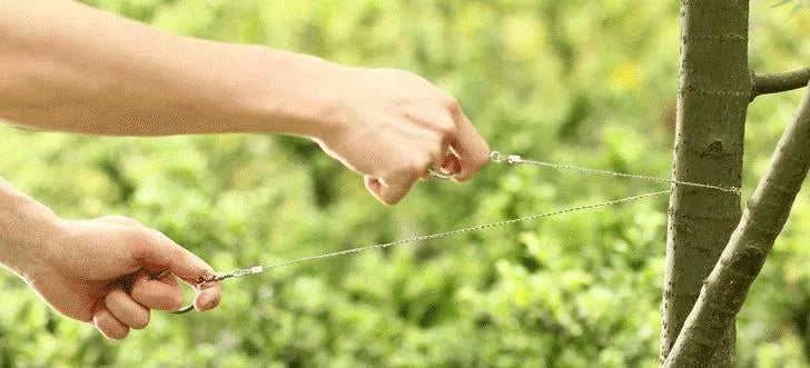 Outdoor survival wire saw with black leather hand case and coiled stainless steel cutting wire.