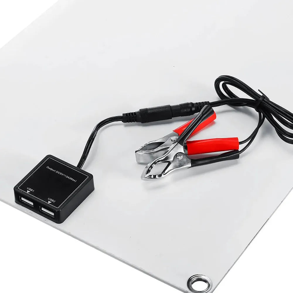 30W semi-flexible black solar panel showing USB port and output cables on a textured surface.