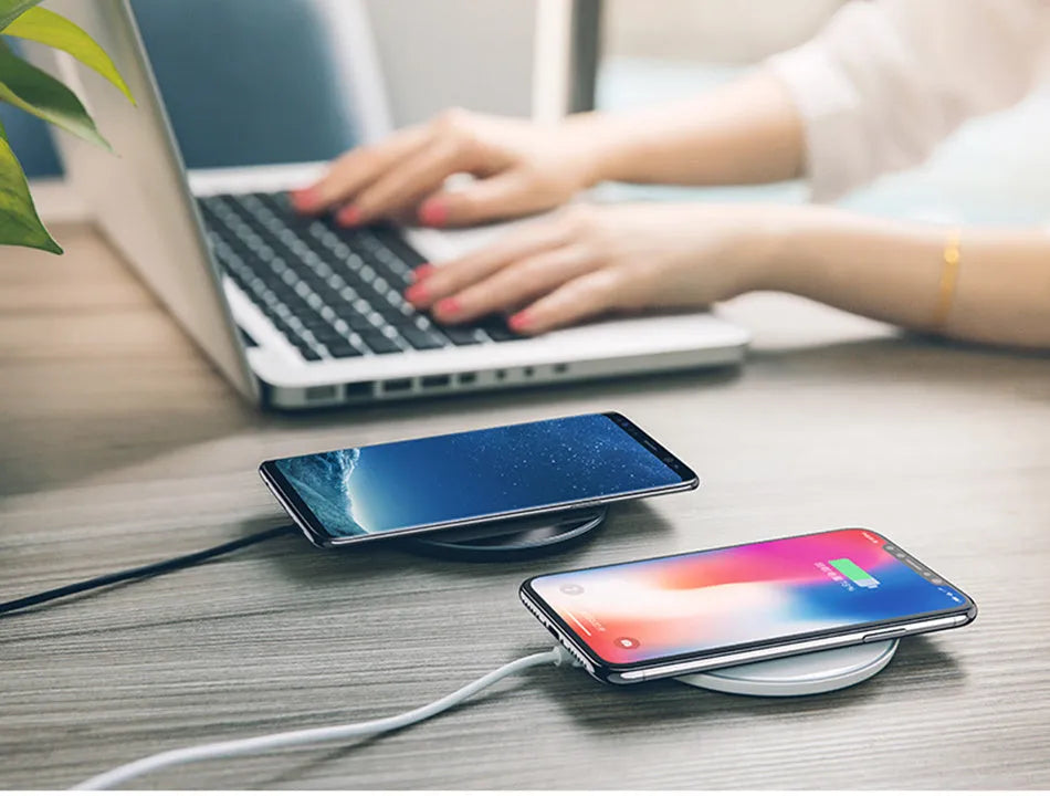 A black or white glass disc wireless charger on a table, showing its sleek design.