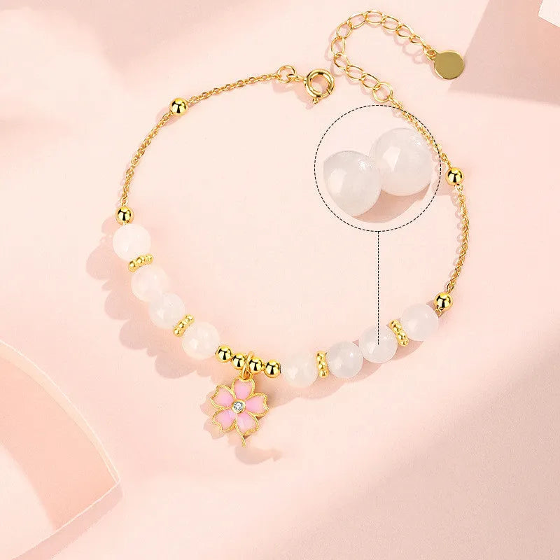 Pink women's bracelet with silver chain, Hetian jade beads, and a detailed cherry blossom flower pendant.