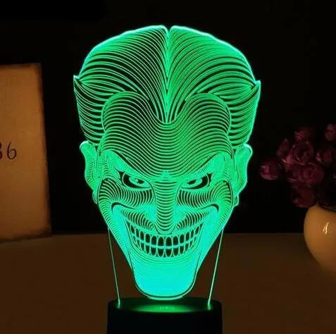 A modern 3D LED table lamp with a colourful gradient display, sitting on a square base with a USB cable.