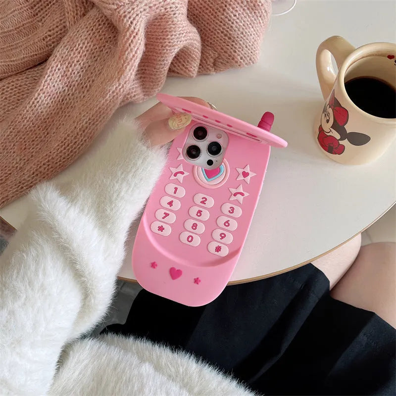Pink silicone flip phone case for iPhone with a built-in compact mirror on the front.