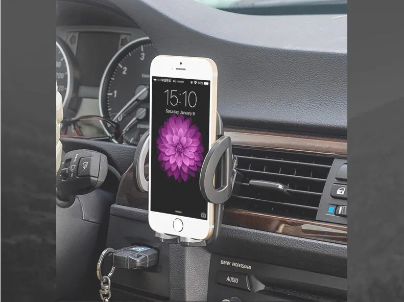 Black plastic universal mobile phone holder attached to a car air conditioning vent.