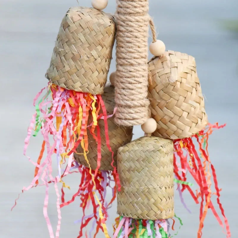 Wooden parrot chewing toy with colourful shredded paper decorations and sisal rope attachments
