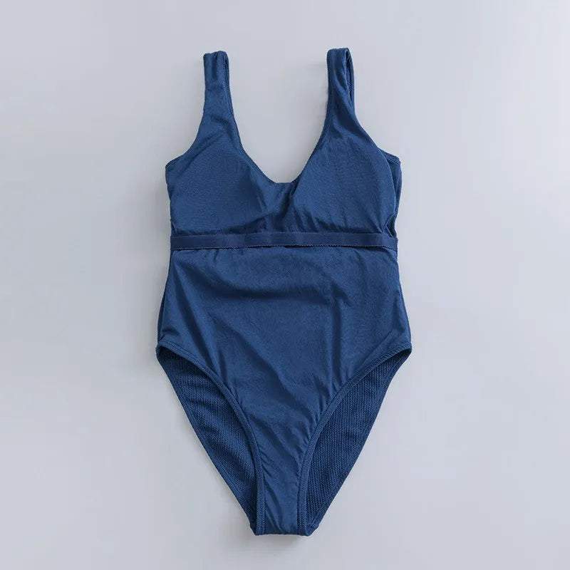 Navy blue women's one-piece swimsuit with triangle cut and chest pads on size chart