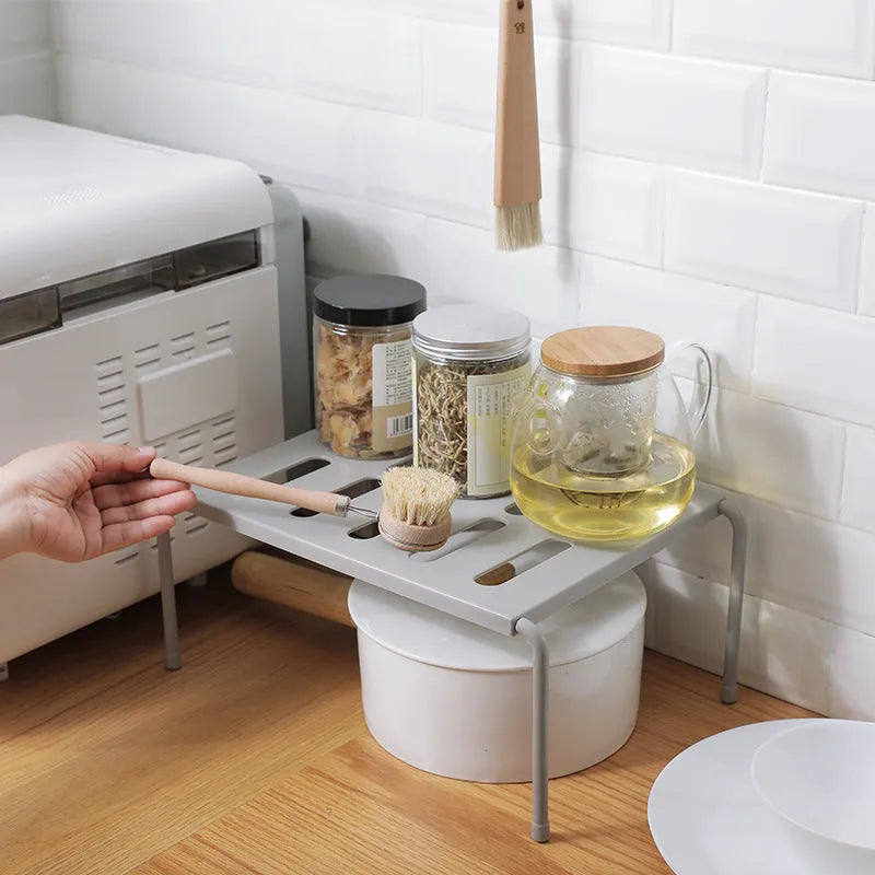 Retractable ABS rack with hollow grid design for kitchen, living room, or bathroom storage, available in grey or white