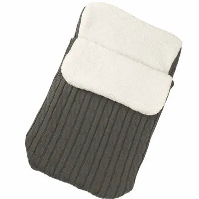 Envelope-style baby stroller sleeping bag in beige colour with thick filling, shown next to a pram.