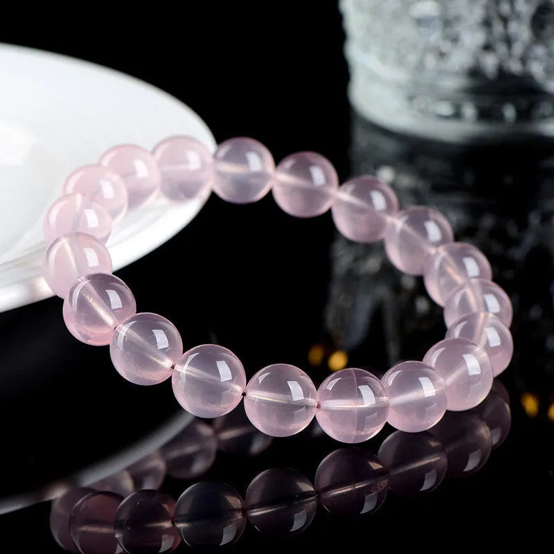 Natural crystal round bead bracelet with polished starlight effect in pink colour, showing bead detail and sizing options