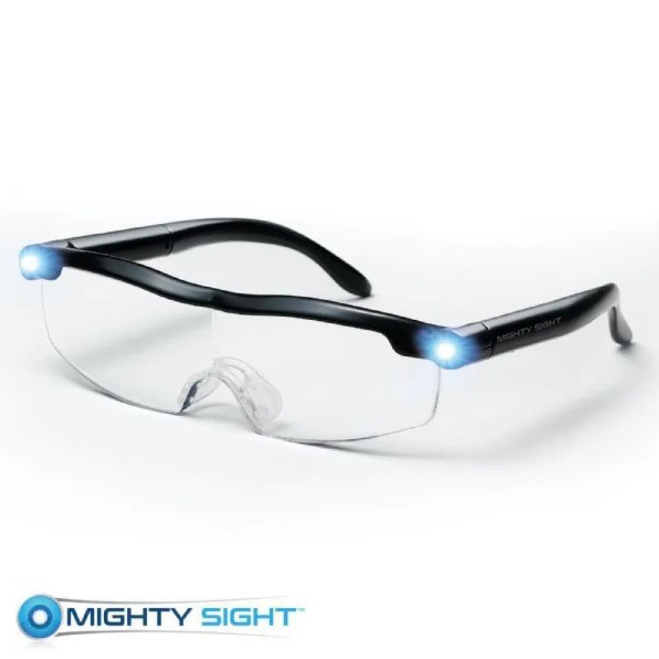 Transparent black USB rechargeable reading glasses with integrated LED light on a dark surface