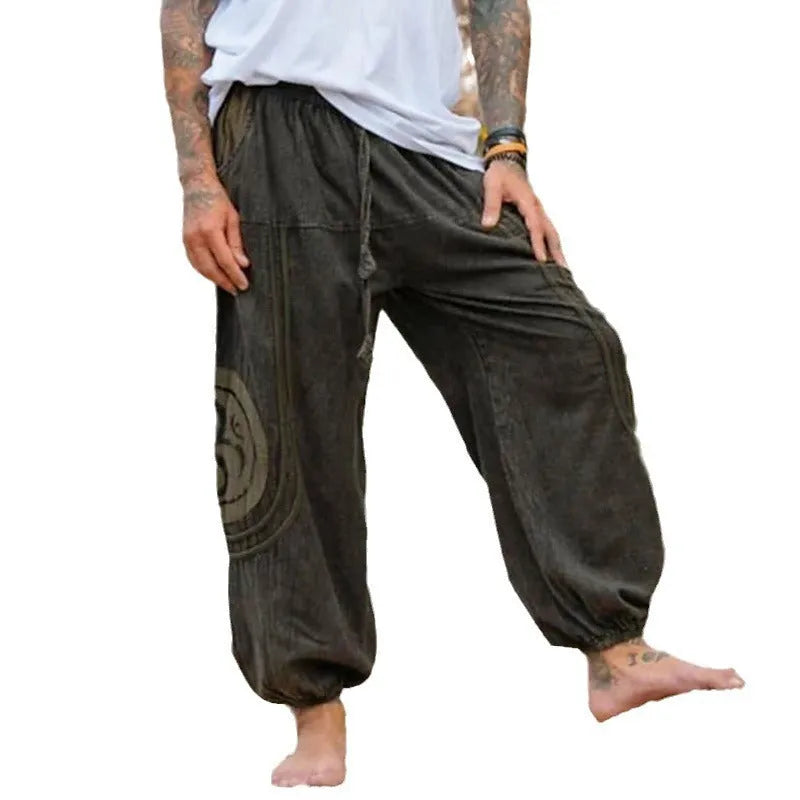 Dark green men's trousers with ethnic pattern design showing ankle-tied detail and mid-waist fit