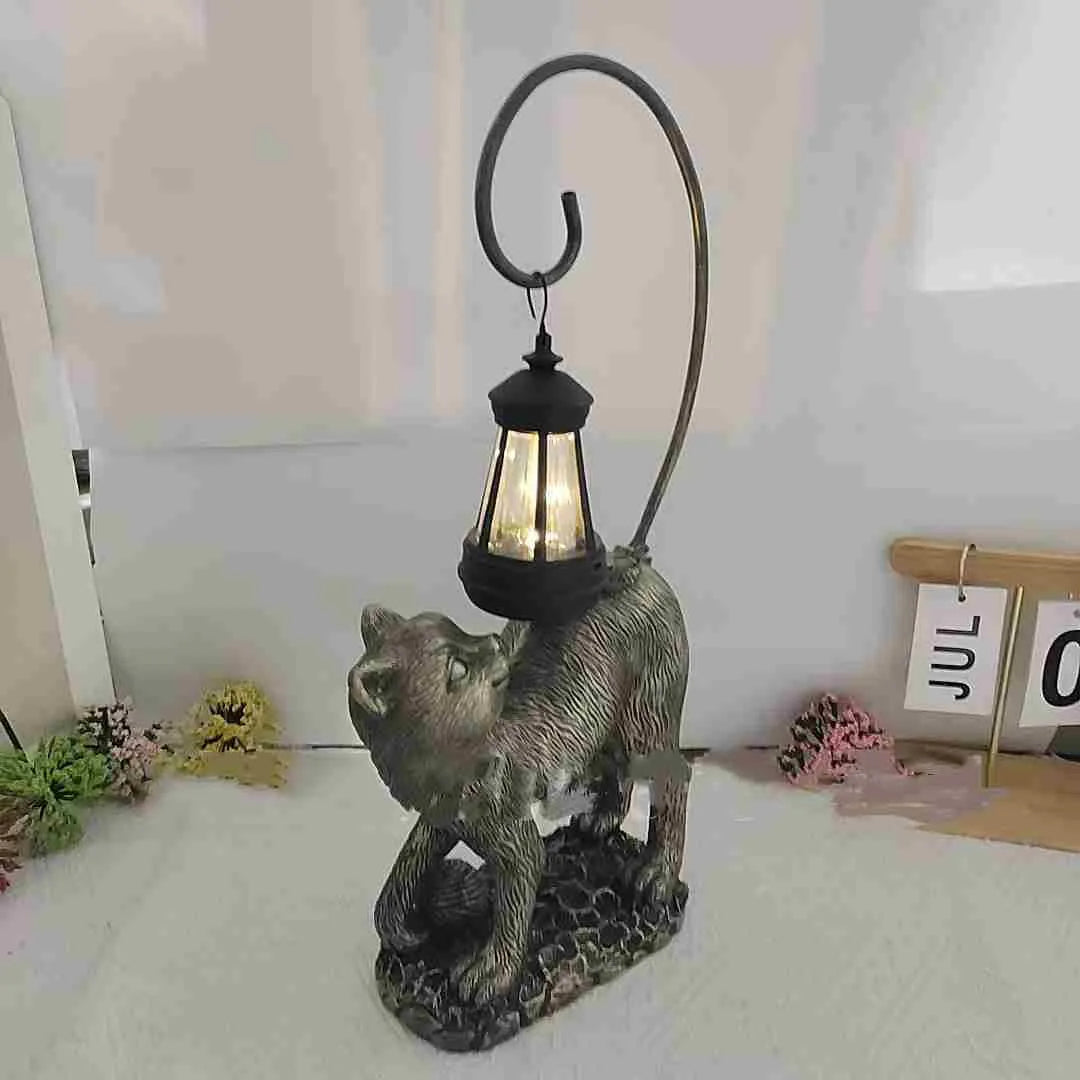 Bronze resin cat solar garden lamp on a garden path, outdoor decoration