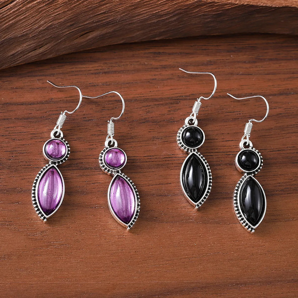 A pair of black and purple vintage geometric drop earrings with a round detail, shown against a plain background.