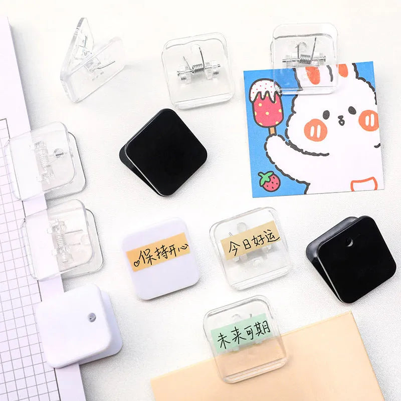 Set of five small square plastic note holders in white, black, and transparent colours