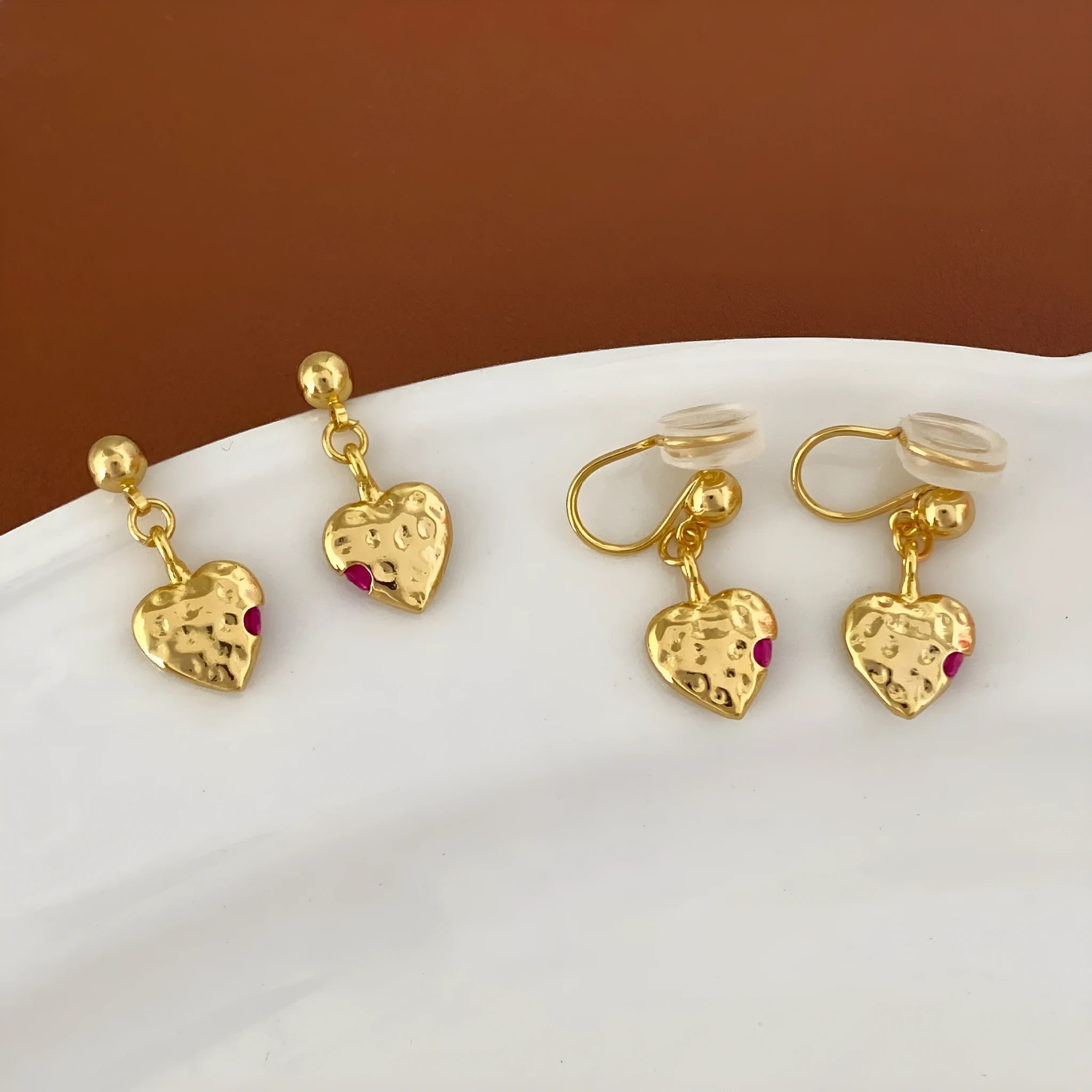 Pair of simple heart-shaped copper earrings with electroplated finish, available as ear clips or studs