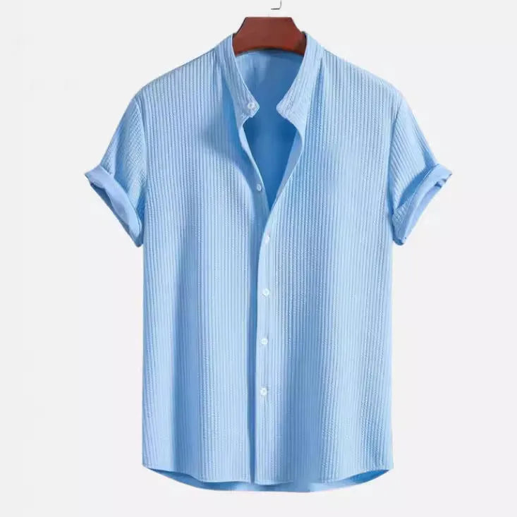 A man's loose-fitting short sleeve casual shirt in a solid colour, made from lightweight polyester fabric.