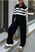Woman wearing a black and white striped long-sleeve polo shirt and matching black casual trousers from a two-piece knit set.
