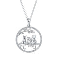 Close-up of a copper necklace with a pendant showing four kitten figures on a cross chain.