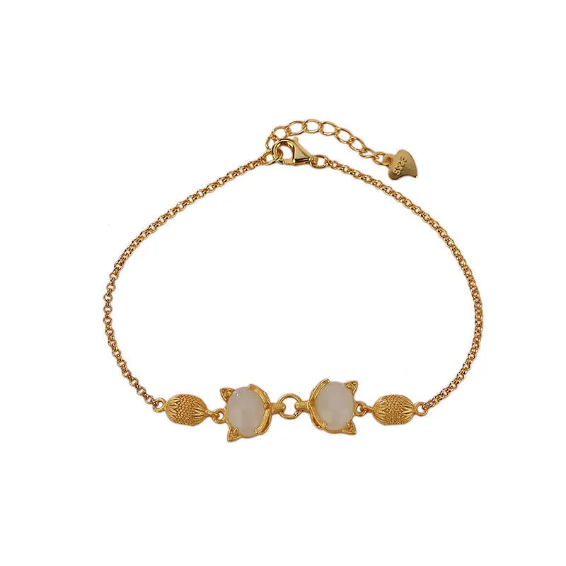 Close-up of a women's silver bracelet with a detailed fox charm and a round stone bead on an adjustable chain.