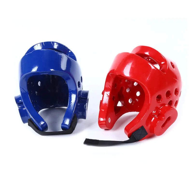 Red and blue karate protective gear set with helmet, boxing gloves and leg guards on training mat