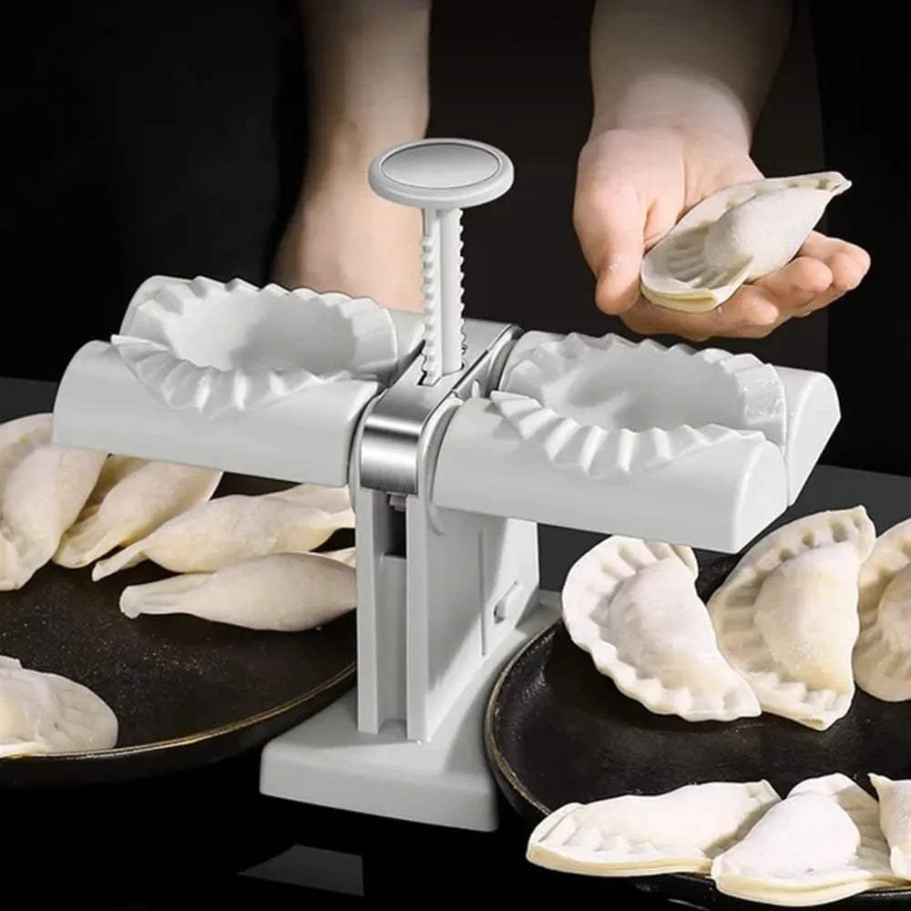 White plastic manual dumpling maker with double head press and anti-slip rubber base mat.