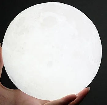 3D printed white moon lamp with textured surface on a wooden stand, showing touch ring at base