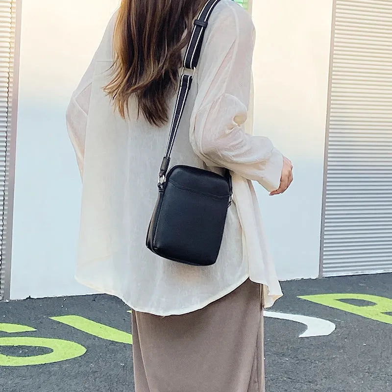 Solid colour crossbody phone bag for women in black, made from PU with an adjustable strap.