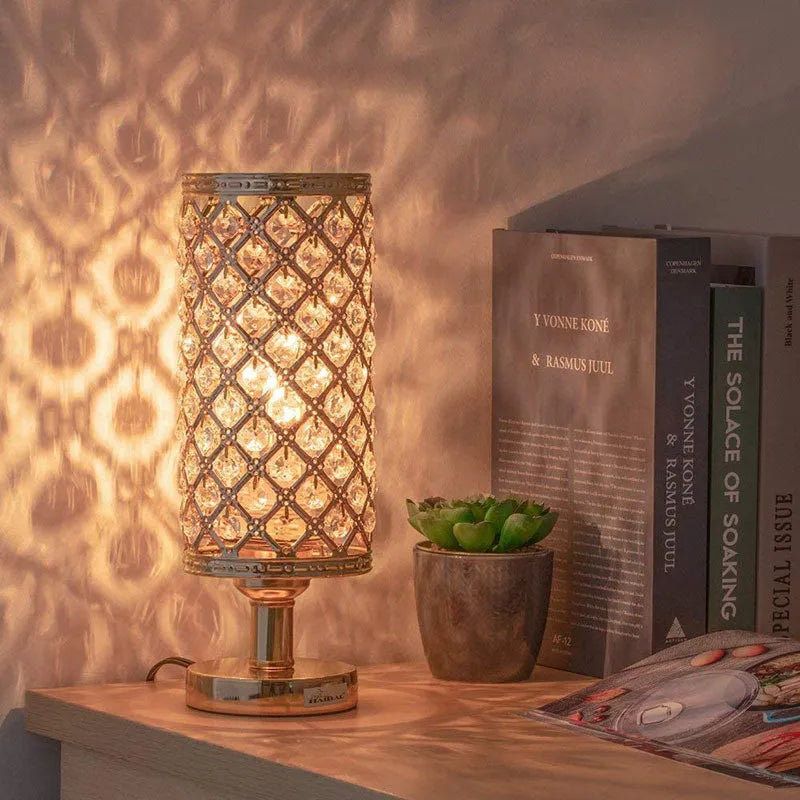 Modern crystal table lamp with hollow-carved design, metal base, gold finish, on bedside table
