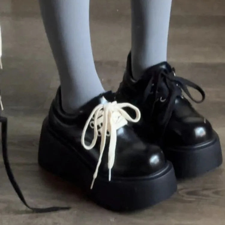 Women's matte black lace-up shoes with a thick sole and English muffin heel.