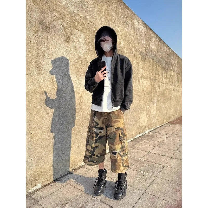 Men's loose-fit camouflage cropped jeans with ripped and patch details on a straight-leg.