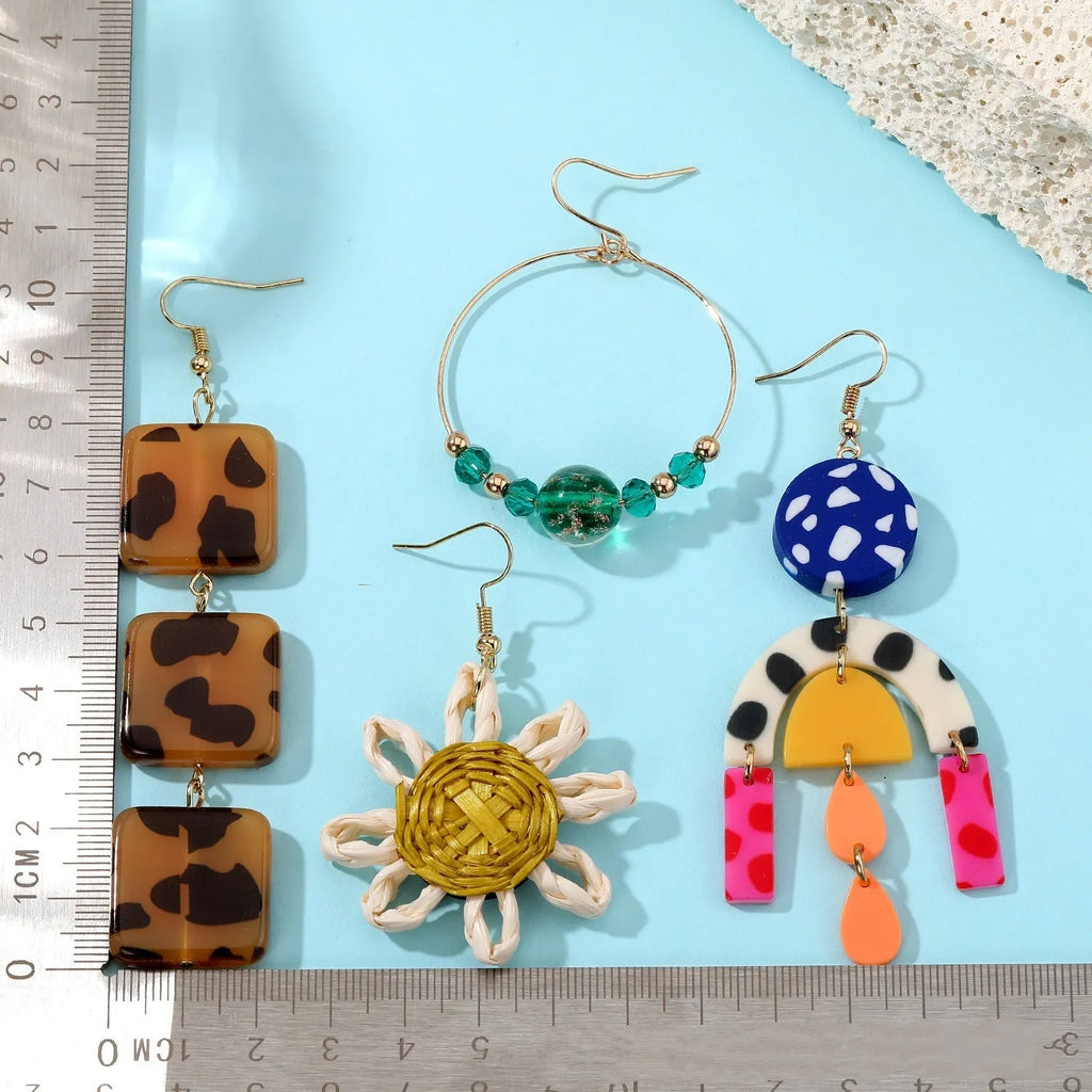 Set of three women's geometric square ear studs with leopard print, sunflower, and coloured glaze bead designs on plastic resin material