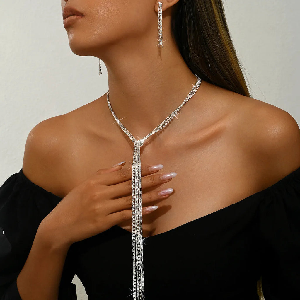 Silver curb chain necklace with rhinestone pendant and matching long earrings in a three-piece set for women