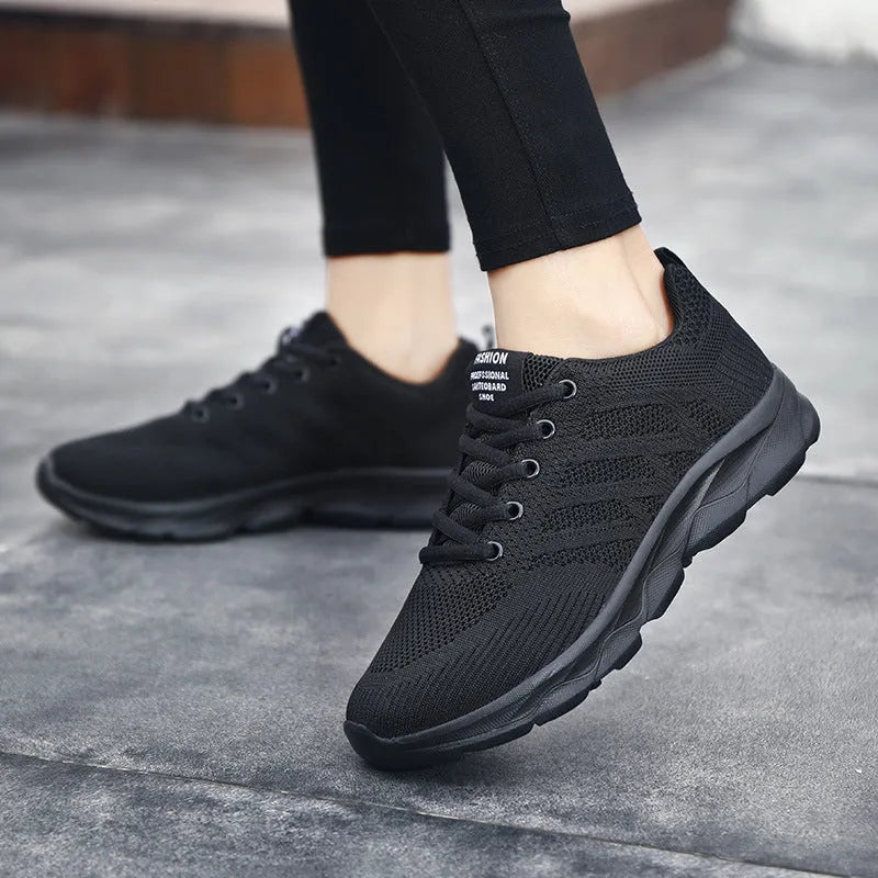 Women's sports running shoes in white with mesh and Flyknit upper, flat heel, and lace-up front