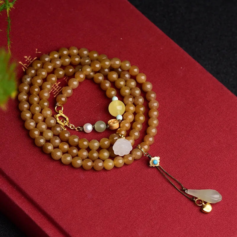 Green jade bracelet with round 6mm beads, beeswax and pine leaf charms on natural background