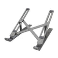 Silver aluminium laptop stand folded flat next to an open laptop, showing its six-angle adjustment hinge.