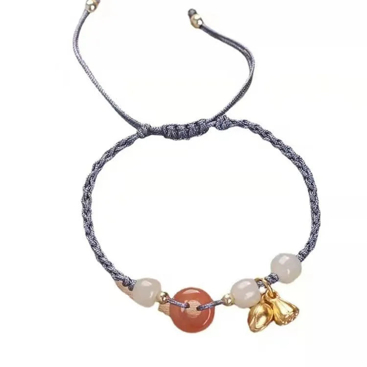 Hetian jade bracelet with constellation design and a brown carrying strap fastened with a Peace Buckle.