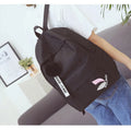 Canvas college backpack with leaf pattern in green colour showing front compartment and straps