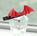 Split Home black patent leather choker collar with devil wings and a central bell on adjustable strap.