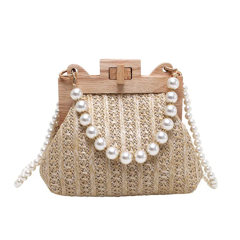 Women's woven straw shoulder bag with pearl chain strap showing internal organisation compartments