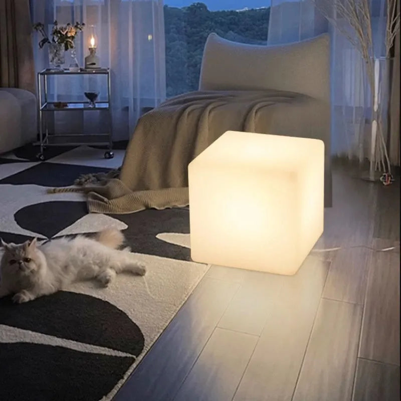 A modern square white LED cube light functioning as a waterproof stool for outdoor gardens.