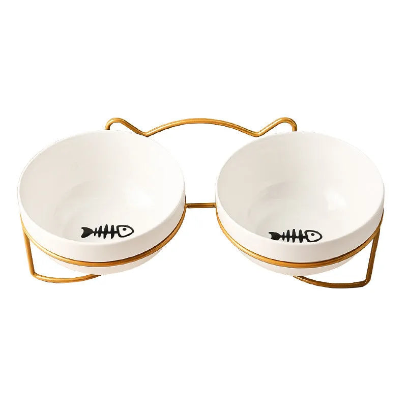 White ceramic cat bowl with cat footprint design on a black iron stand with cat ears.