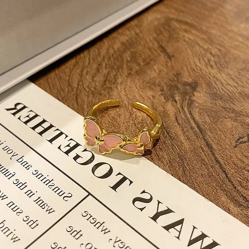 Copper butterfly women's ring with dripping oil texture and an open loop design.