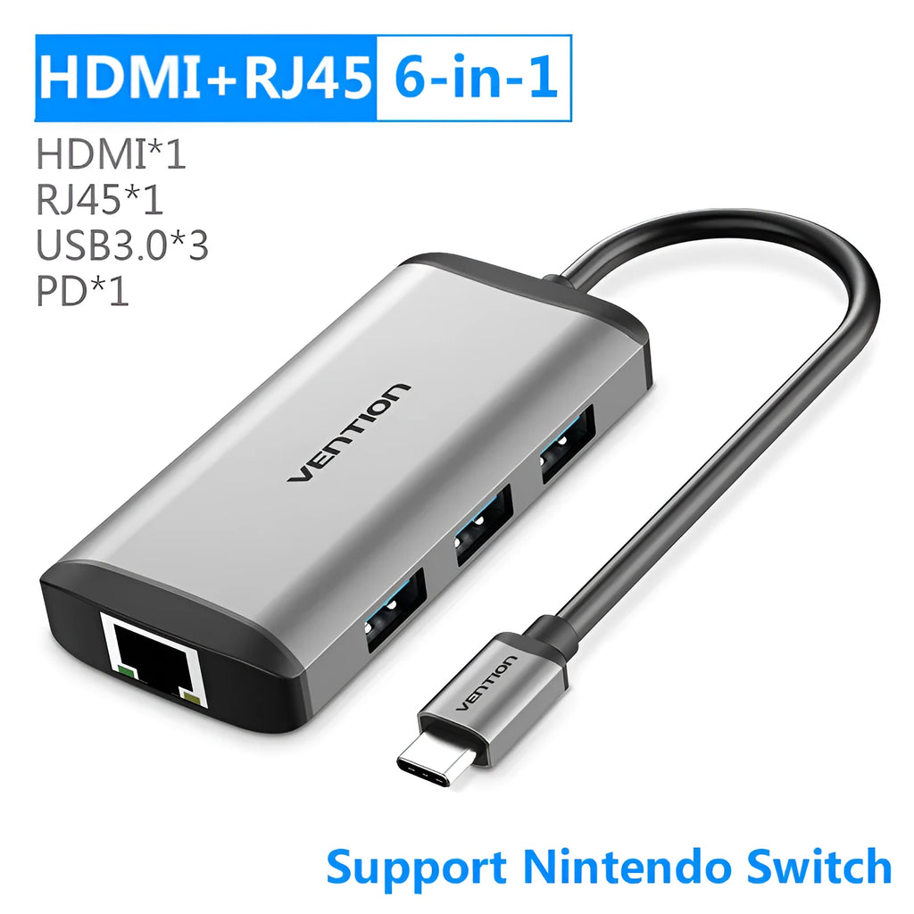 Deep grey USB-C docking station hub showing HDMI, USB, Ethernet, and memory card ports on a desk.