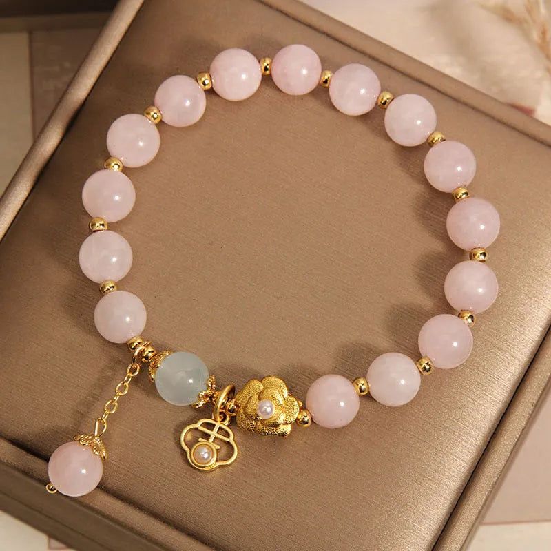 Women's pink crystal bracelet with a refined grace flower design on a wrist.