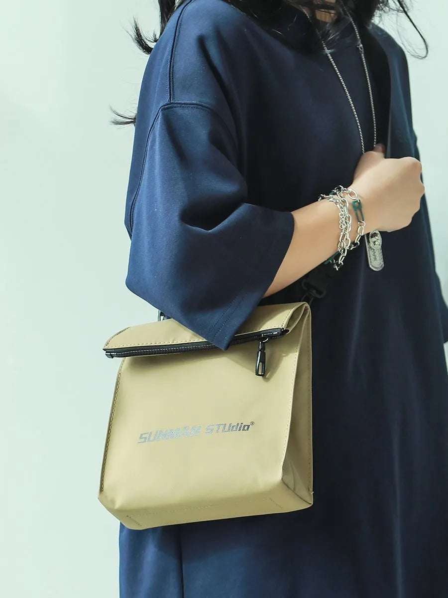 Simple messenger backpack in Oxford fabric with contrast stitching, shown in a choice of four colours.